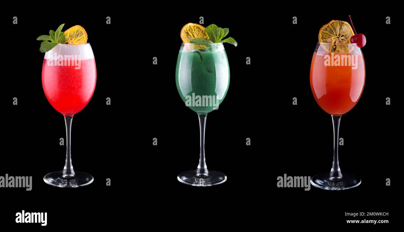 Non-alcoholic cocktails of different colors in cocktail glasses with mint, cherry and ice. Isolated on black Stock Photo