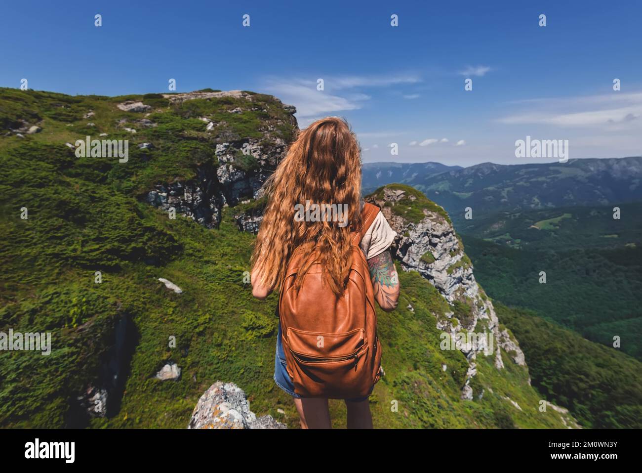 Girl Backpacker Standing Alone on Rock of Mountain Stock Photo