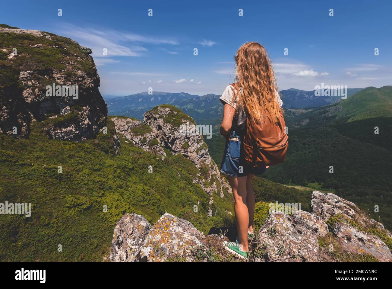 Woman Backpacker Standing Alone on Rock of Mountain Stock Photo