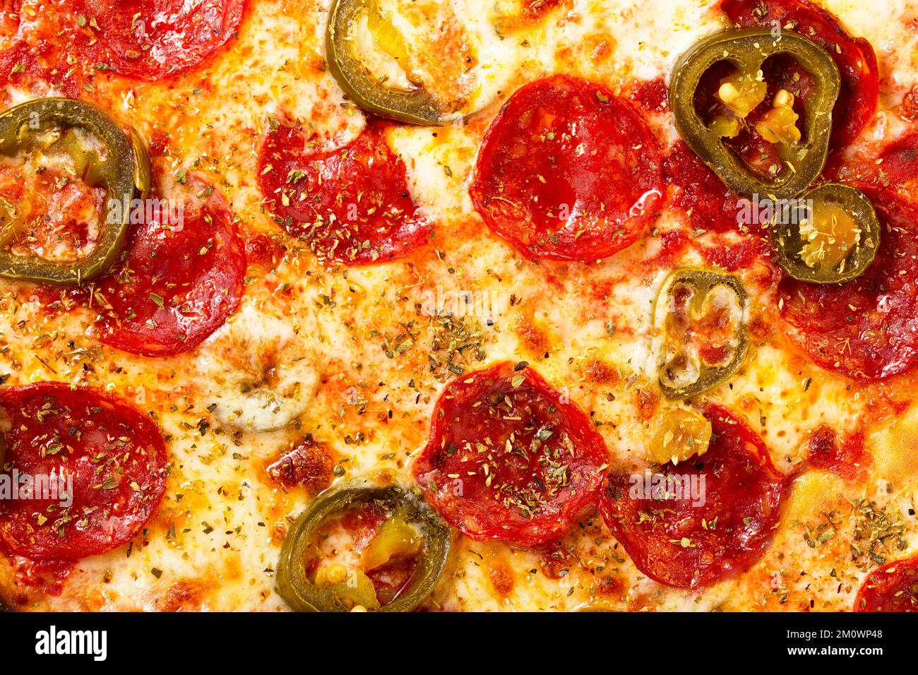 Salami pepperoni pizza texture with jalapeno as background. A close ...