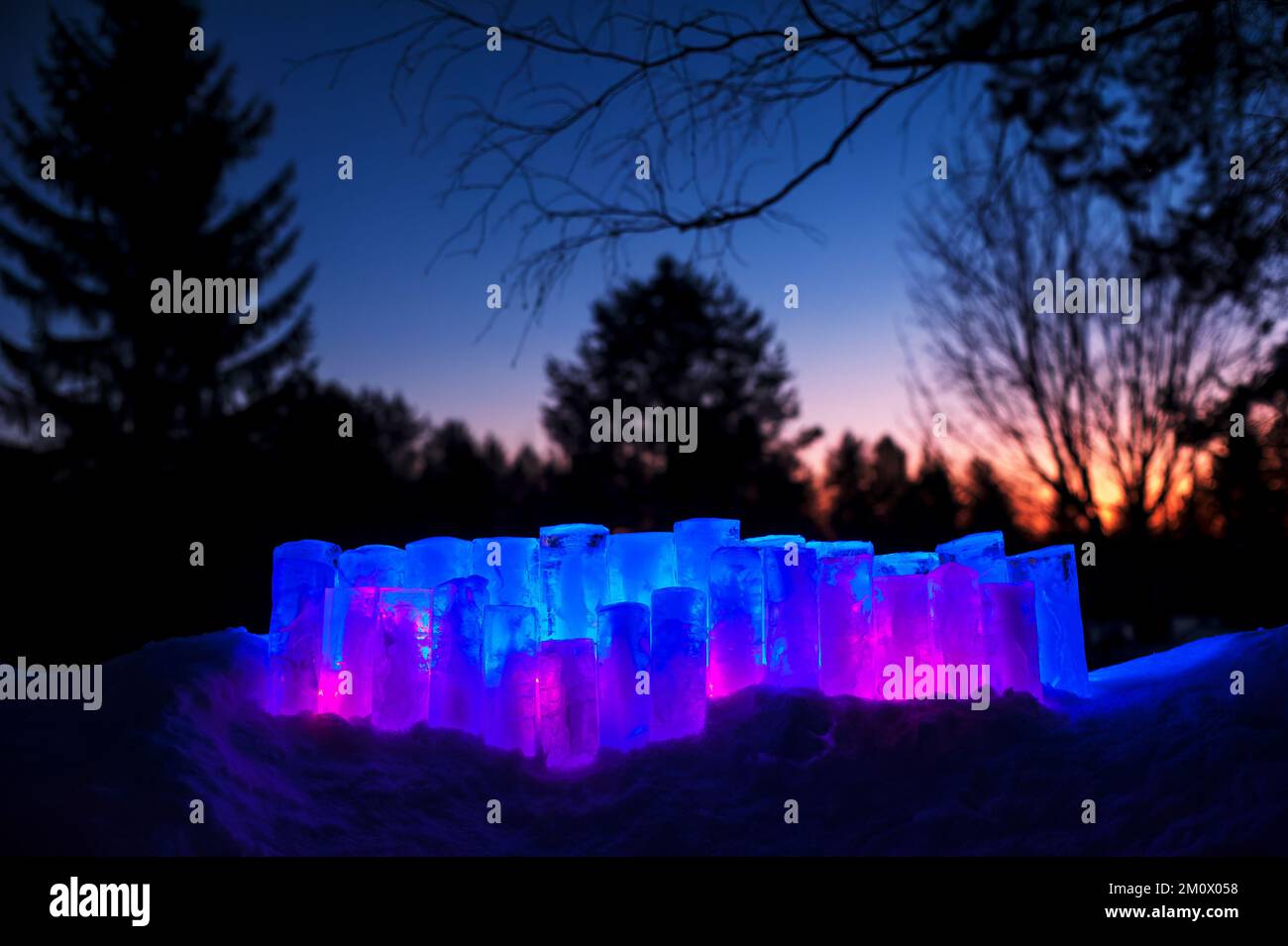 Ice lanterns with led lights in snow. Winter evening in the garden. Stock Photo