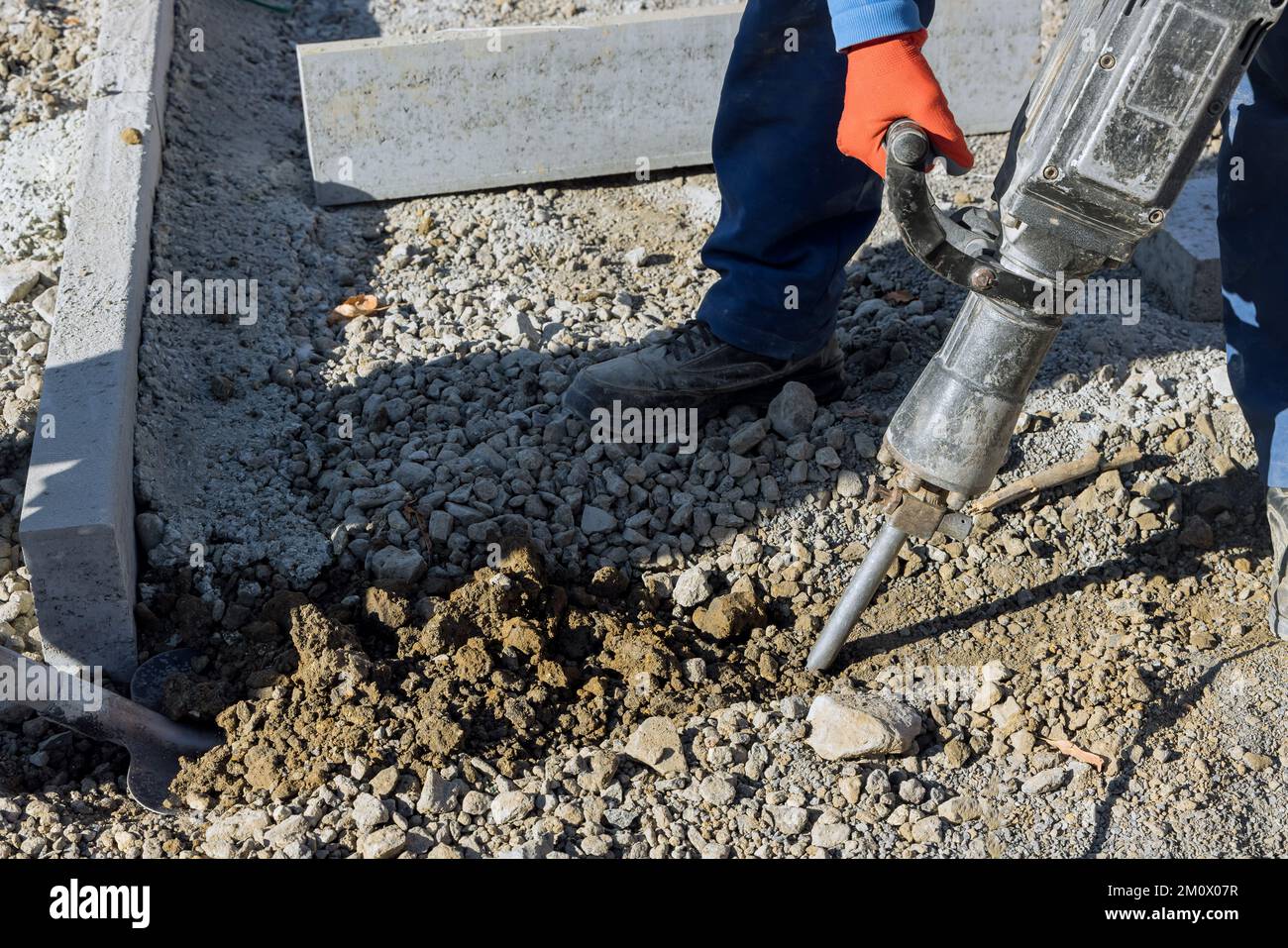 Construction road workers using jackhammer digging concrete surface