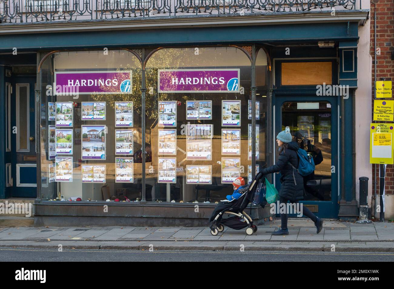 Windsor, Berkshire, UK. 8th December, 2022. A woman walks past an Estate Agents in Windsor. As the cost of living crisis continues, house prices fell in November by 2.3% at the fastest rate in 14 years according the Halifax. Credit: Maureen McLean/Alamy Live News Stock Photo