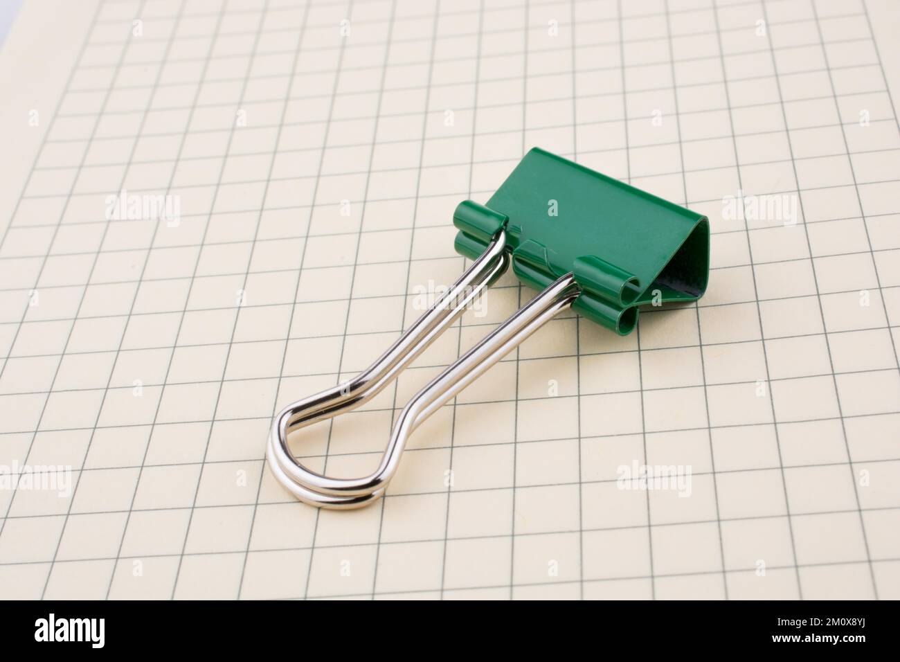 Colored paper clip on a checked notebook page Stock Photo