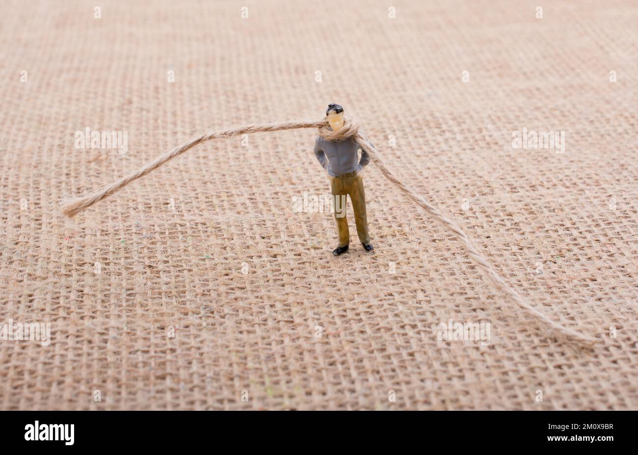 Figurine man with a rope on the neck Stock Photo - Alamy