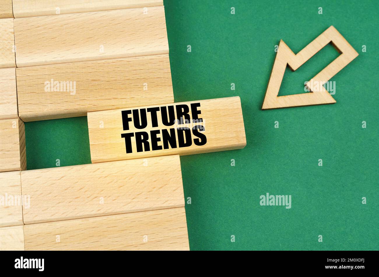 Business concept. On the green surface are wooden plates and an arrow that points to a plate with the inscription - Future trends Stock Photo