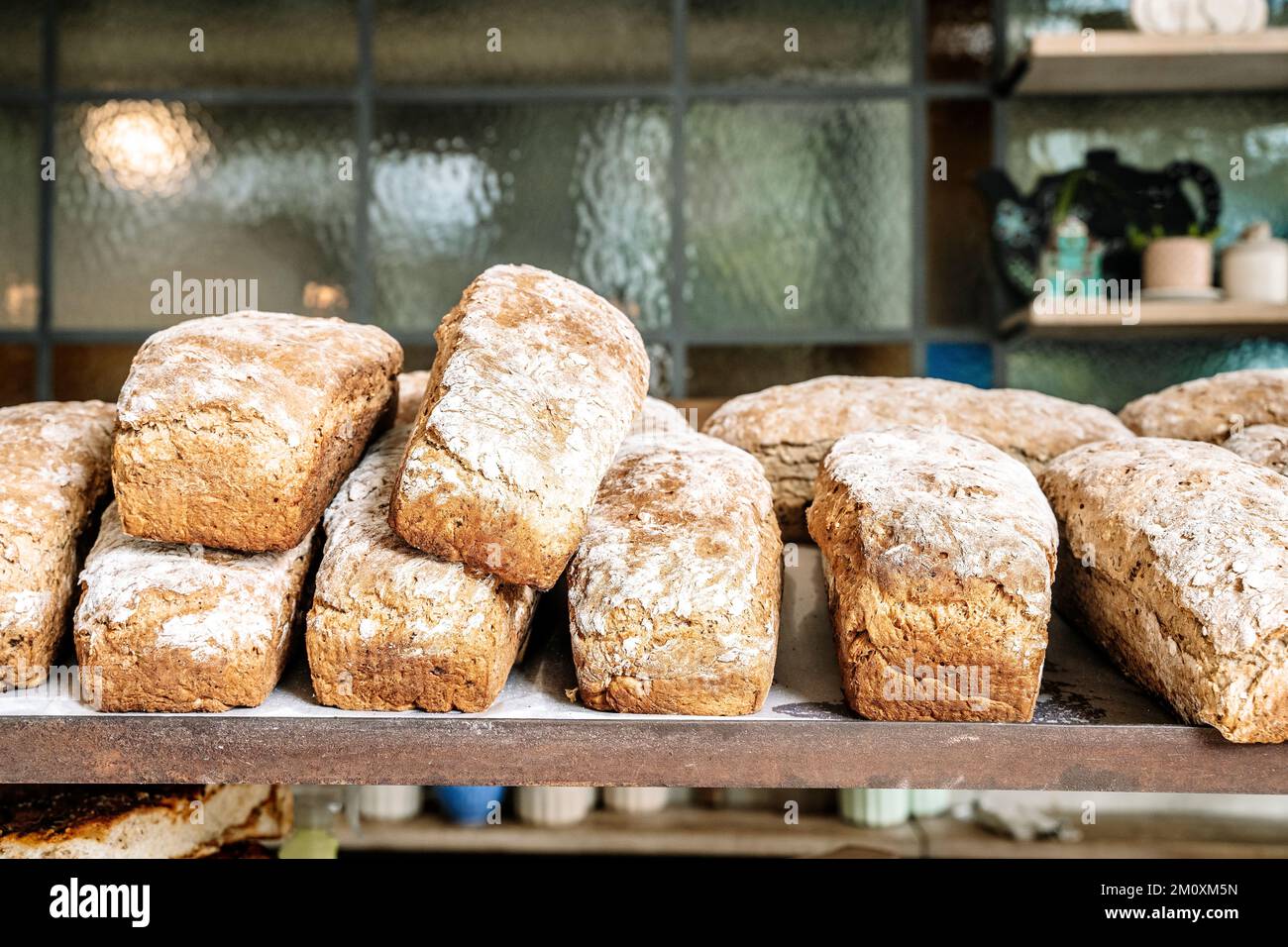 Loaves of bread on the shelves of the shop bakery counter. Fresh, homemade wheat and whole grain breads and pastries. High quality photo Stock Photo