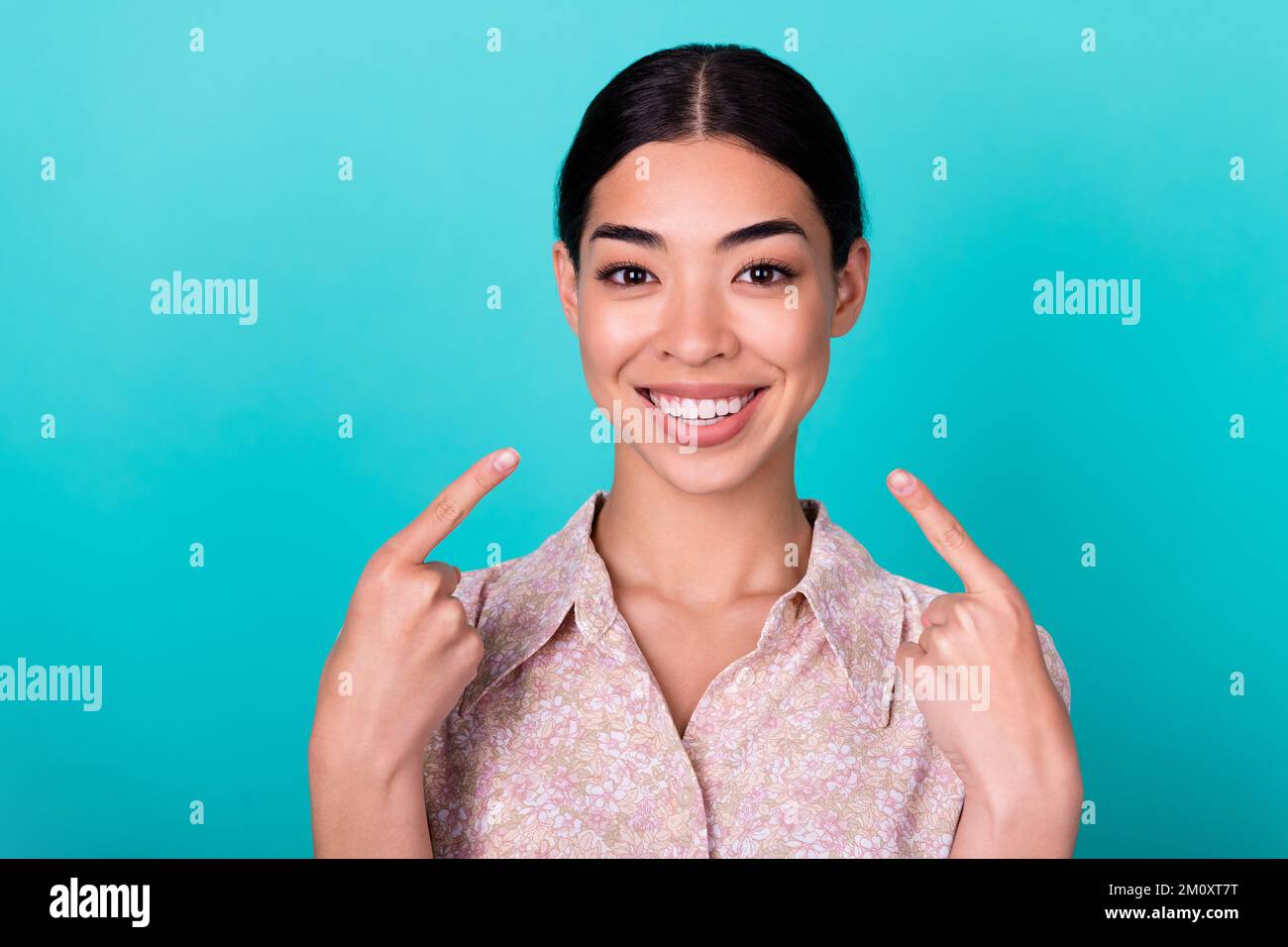 Photo of attractive cheerful lady indicate fingers toothy beaming smile isolated on teal color background Stock Photo