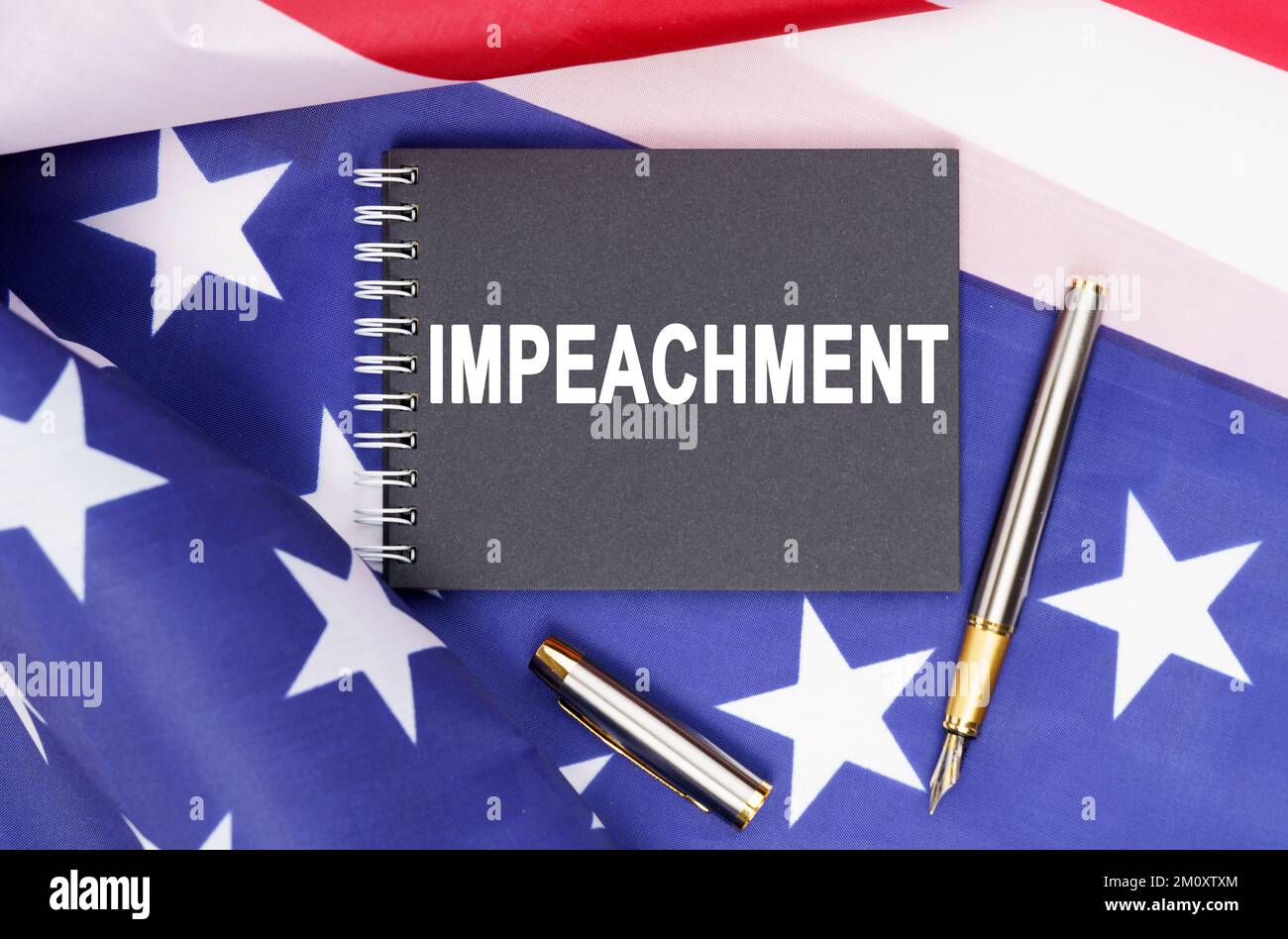 American concept. The US flag has a pen and a notebook with the inscription - IMPEACHMENT Stock Photo
