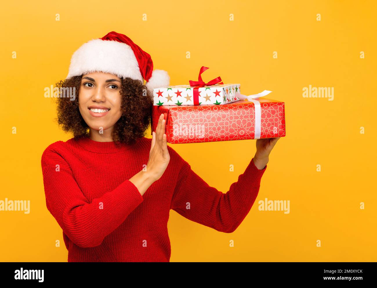 Happy African American woman holds in hands stack of christmas gifts. smiling. Xmas Stock Photo