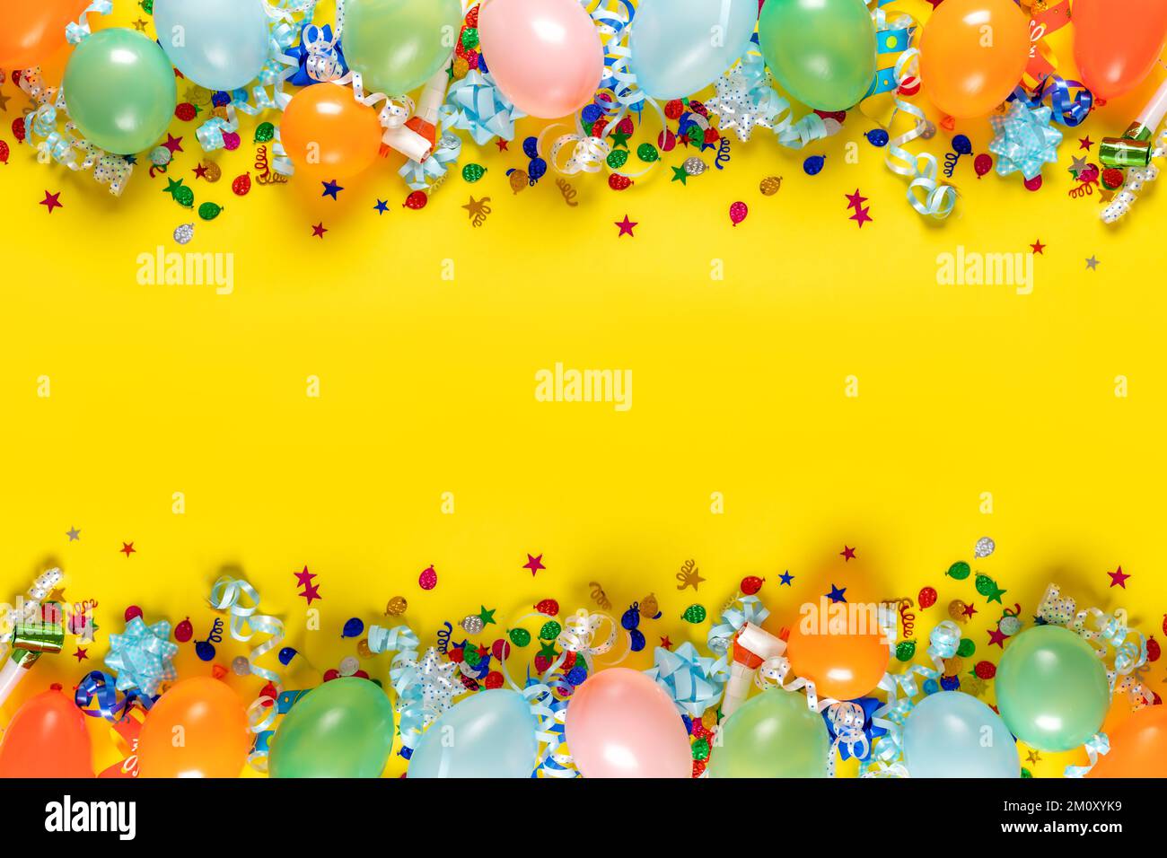 Birthday background top view. Frame of balloons and various party decorations on yellow background Stock Photo