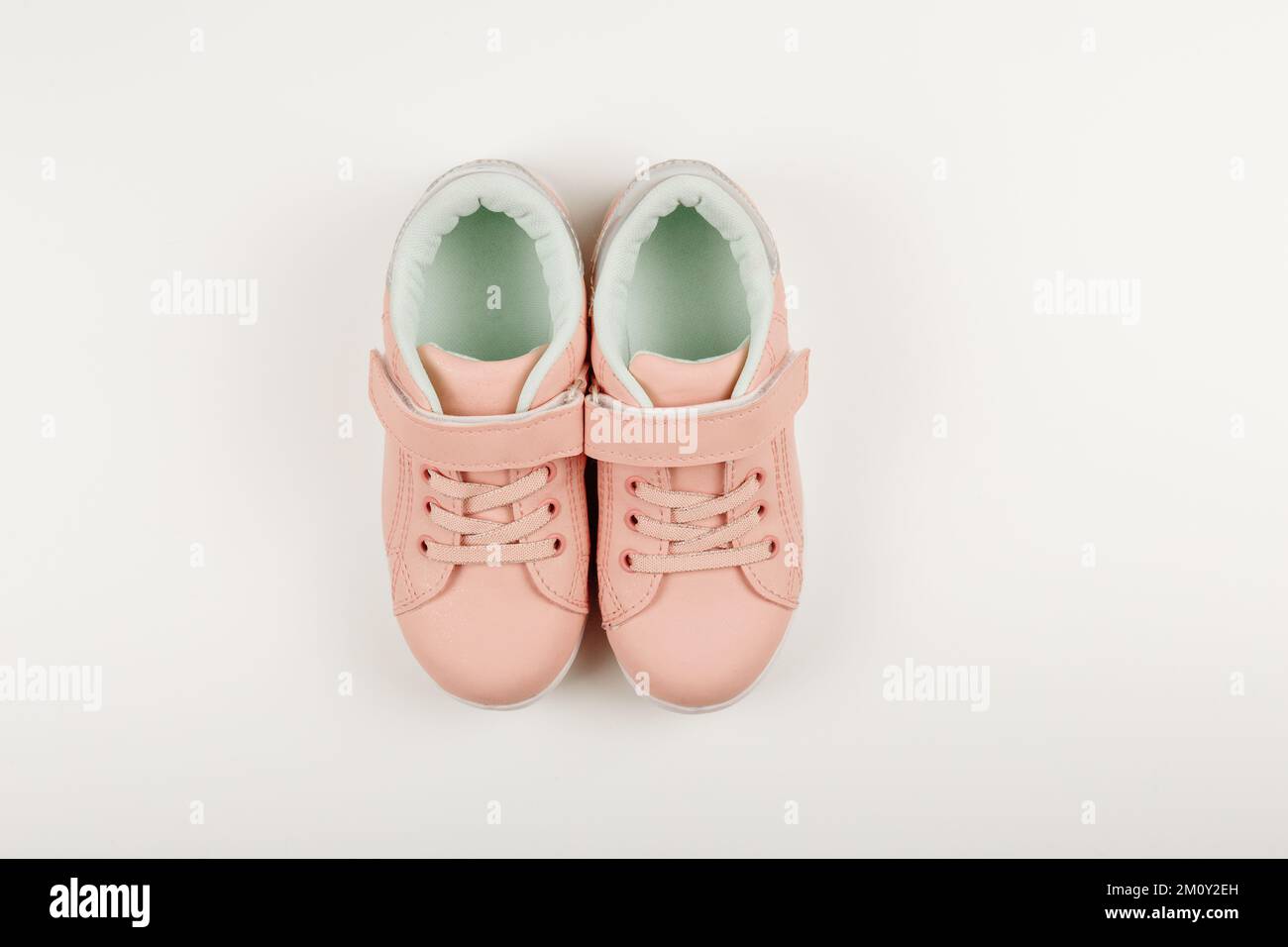 Cute pink children's sneakers. White background. Baby clothes and shoes. Flatlay,copy space Stock Photo