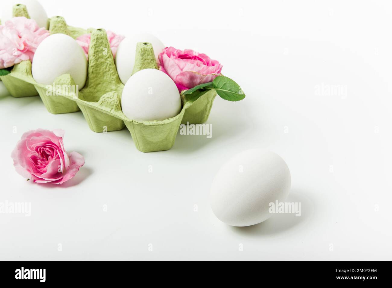 Easter composition of eggs and pink flowers. White background. Easter ...