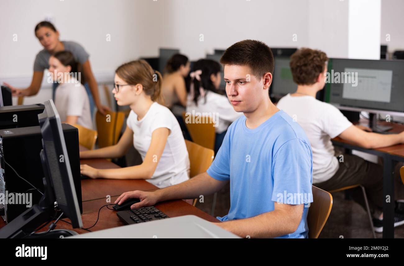Modern boy student learning basics of programming in course in computer ...