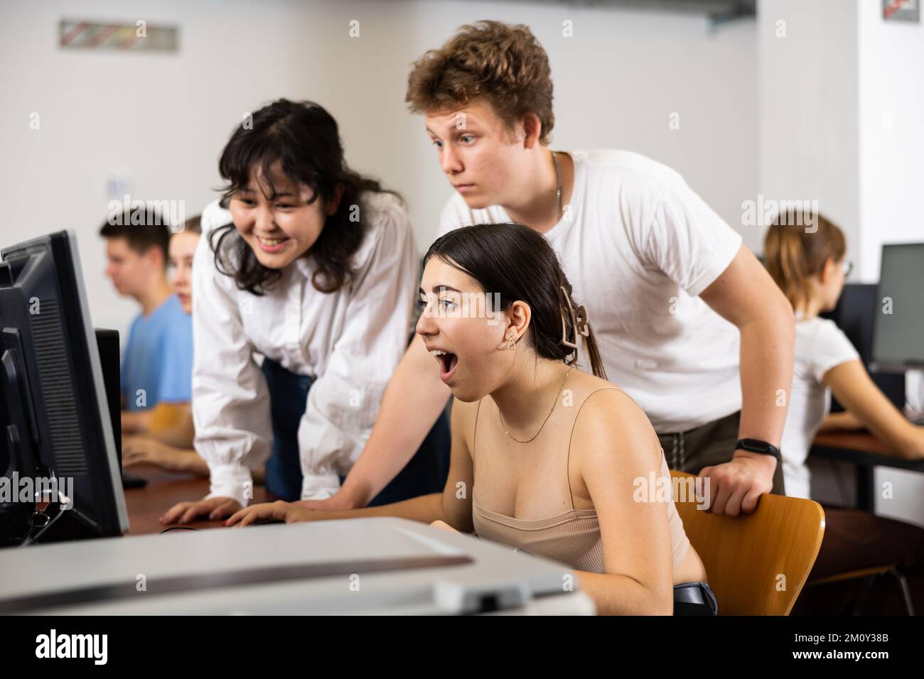 Cheerful teenager boy and girls studying in computer class Stock Photo