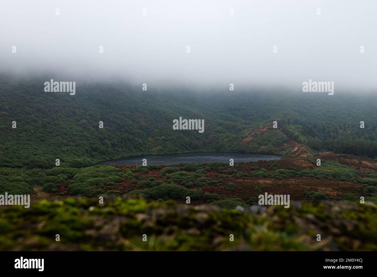 Lake in the mountains with low clouds passing by. The Bay Lough, Clogheen, Tipperary, Ireland. Stock Photo