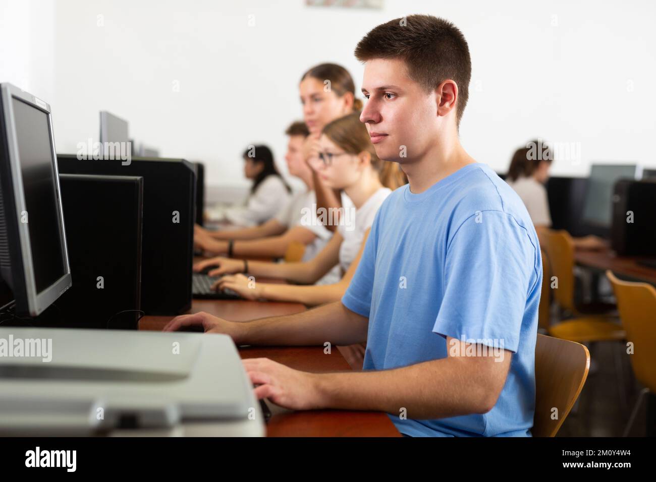 Teenage boy learning to use personal computer during lesson Stock Photo ...