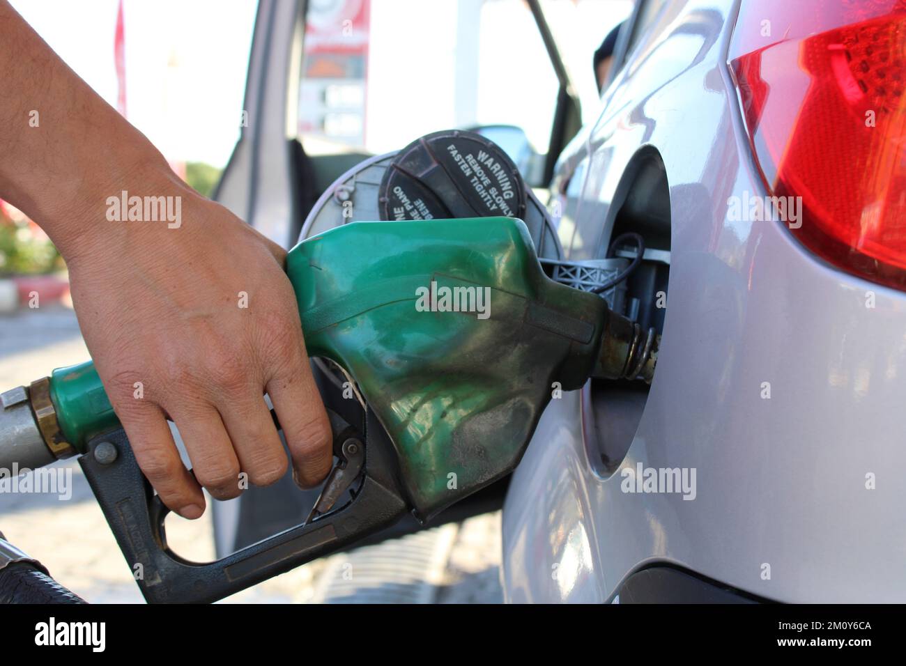 pump in the car. male hand filling gasoline to the car. For petrol and gas hike news. Stock Photo