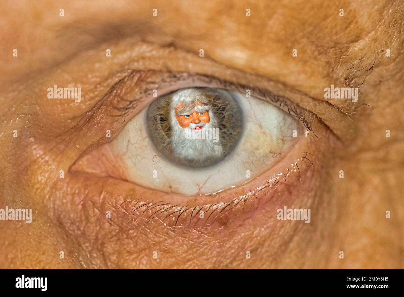 Santa Claus reflected in the eye of a senior citizen Stock Photo