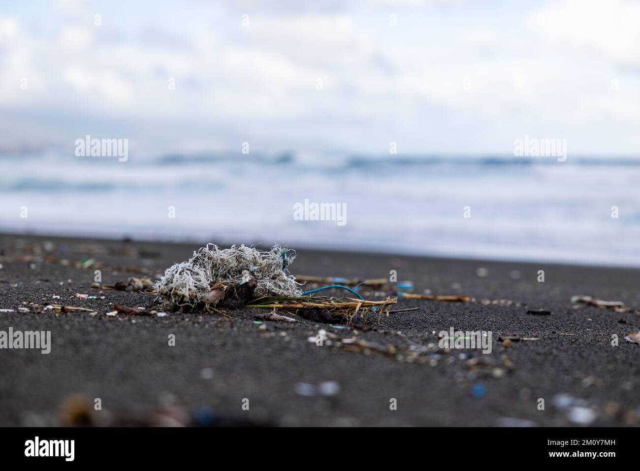 Trash in the sand, plastic waste by the ocean, sad and unsustainable