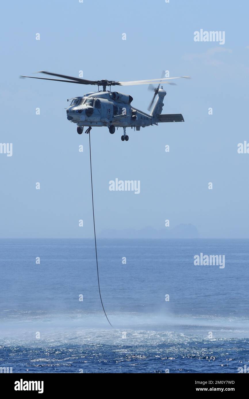 A patrol helicopter of the Japan Maritime Self-Defense Force hovering over the sea. Stock Photo