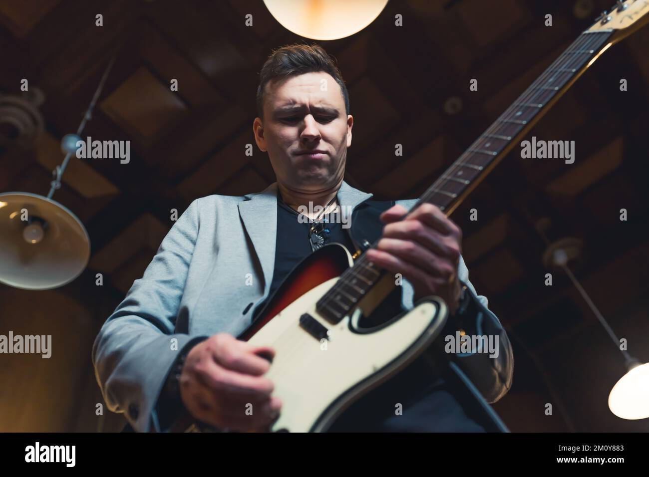 Low-angle shot of a man playing electric guitar. High quality photo Stock Photo