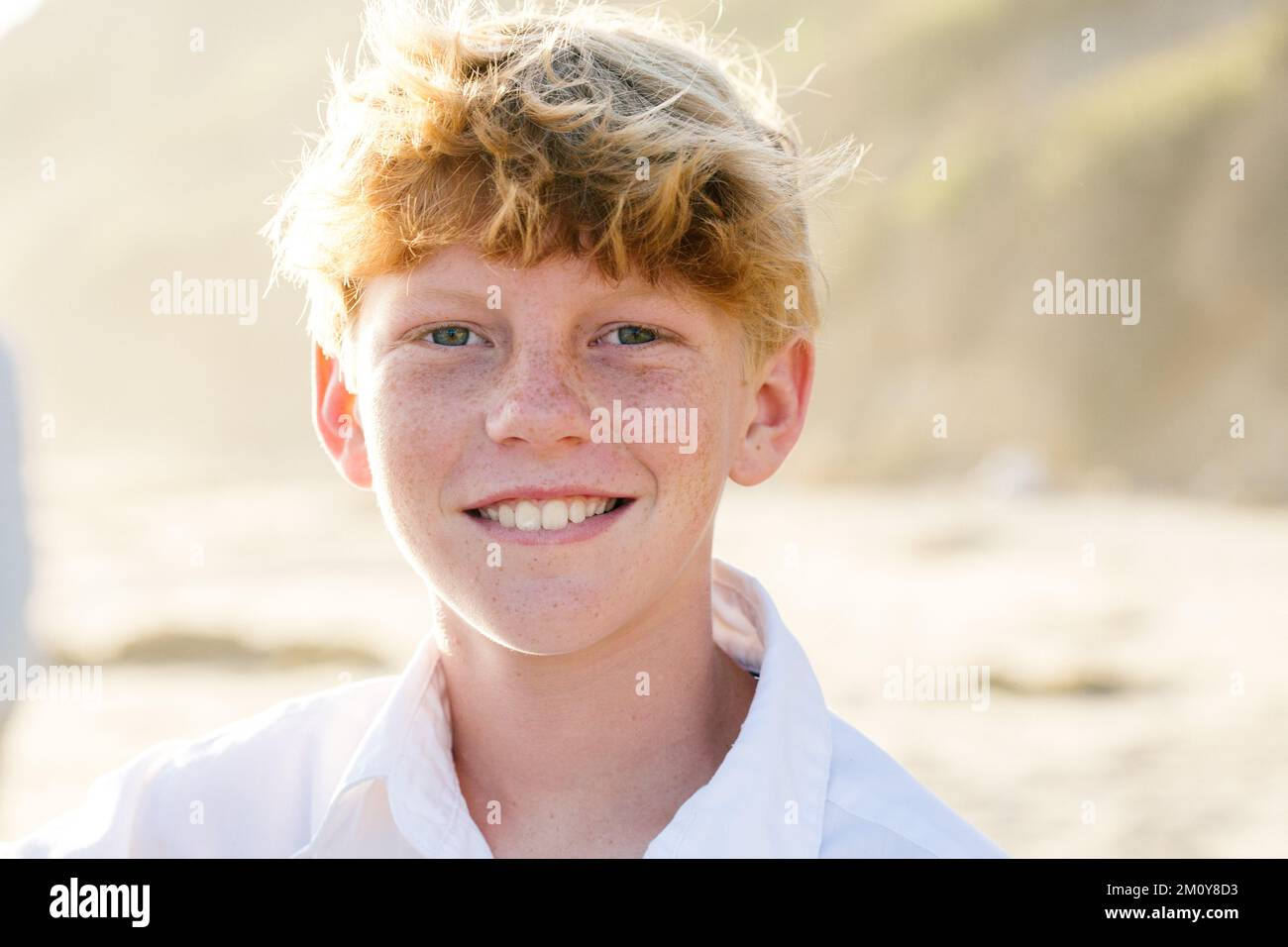 Tween Boy With Red Hair And Freckles Smiles At The Beach Stock Photo