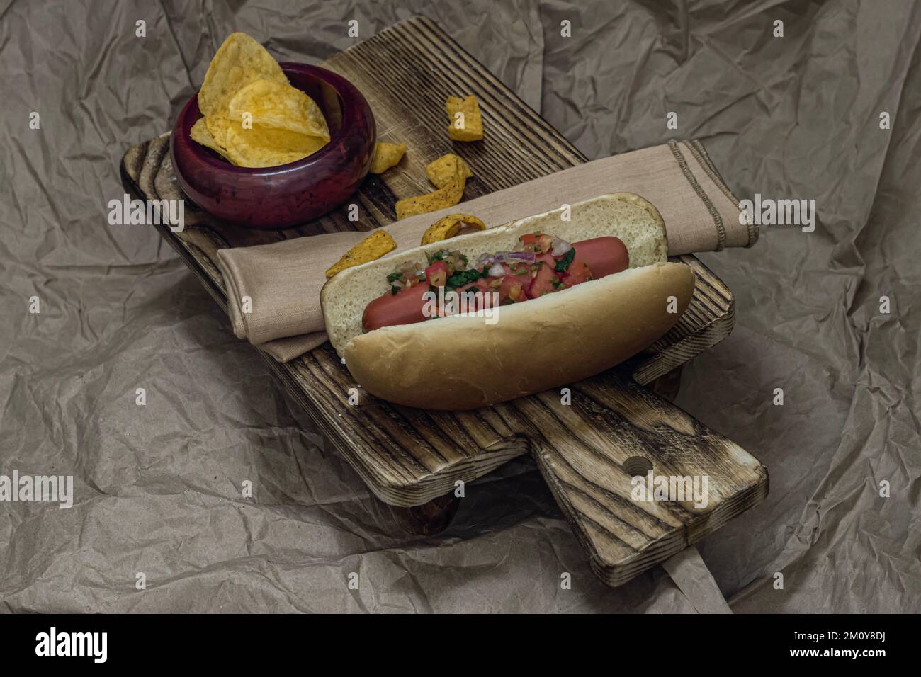 Hotdog with salsa potato chips and corn chips. Stock Photo