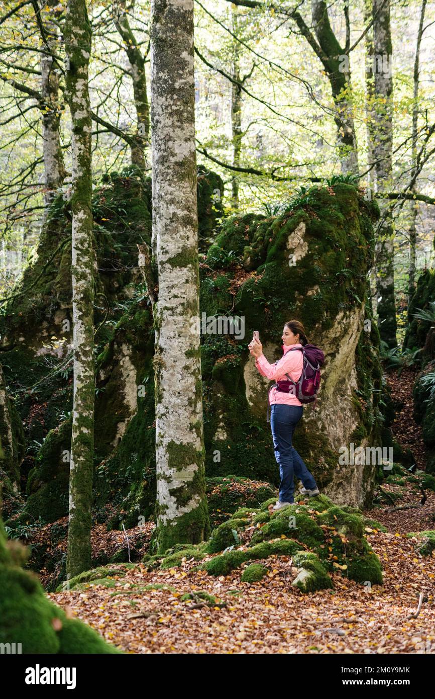 Hiker woman photographing the landscape with smartphone. Stock Photo