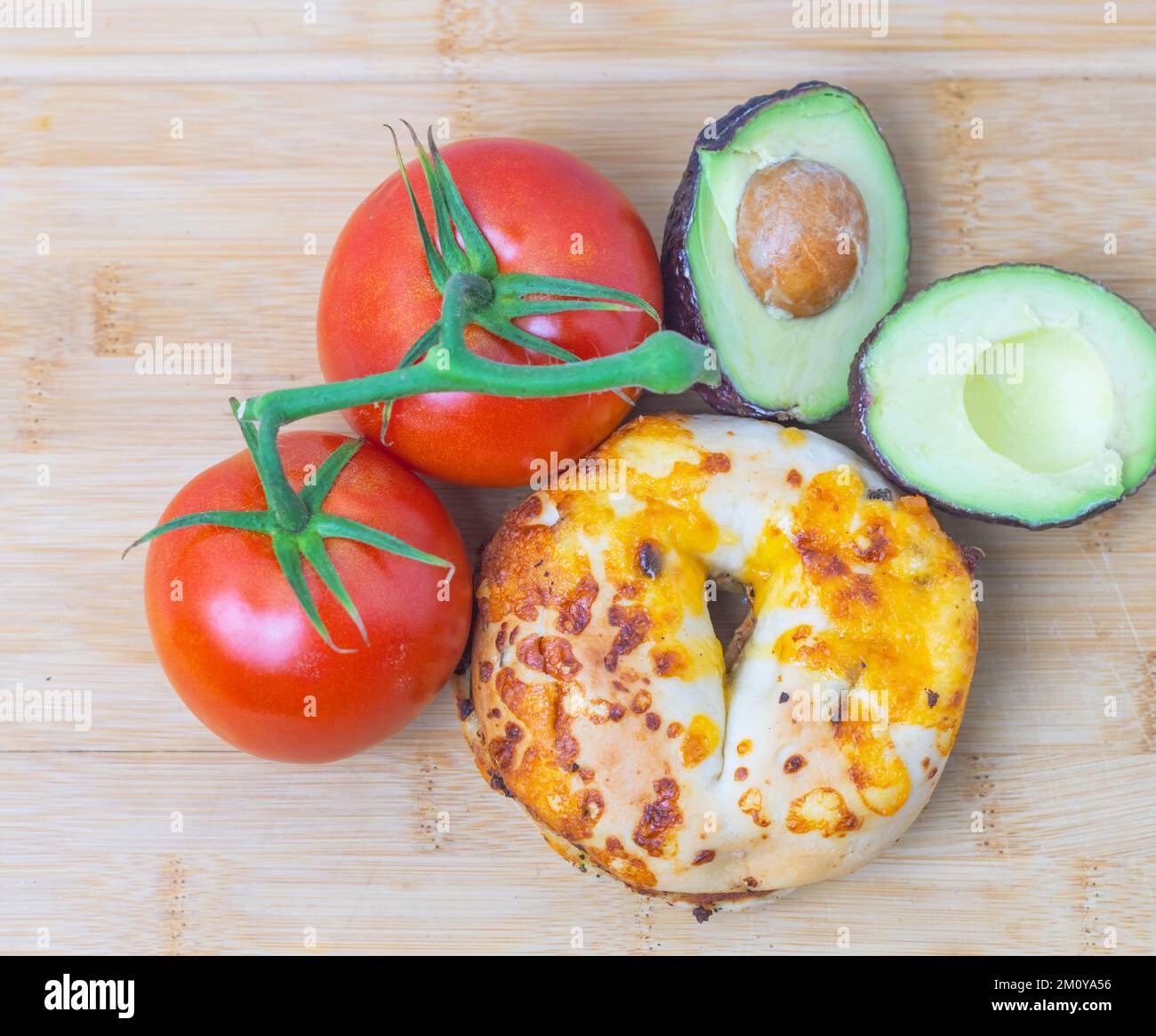 Toasted bagel composed with tomato and avocado, top down perspective Stock Photo