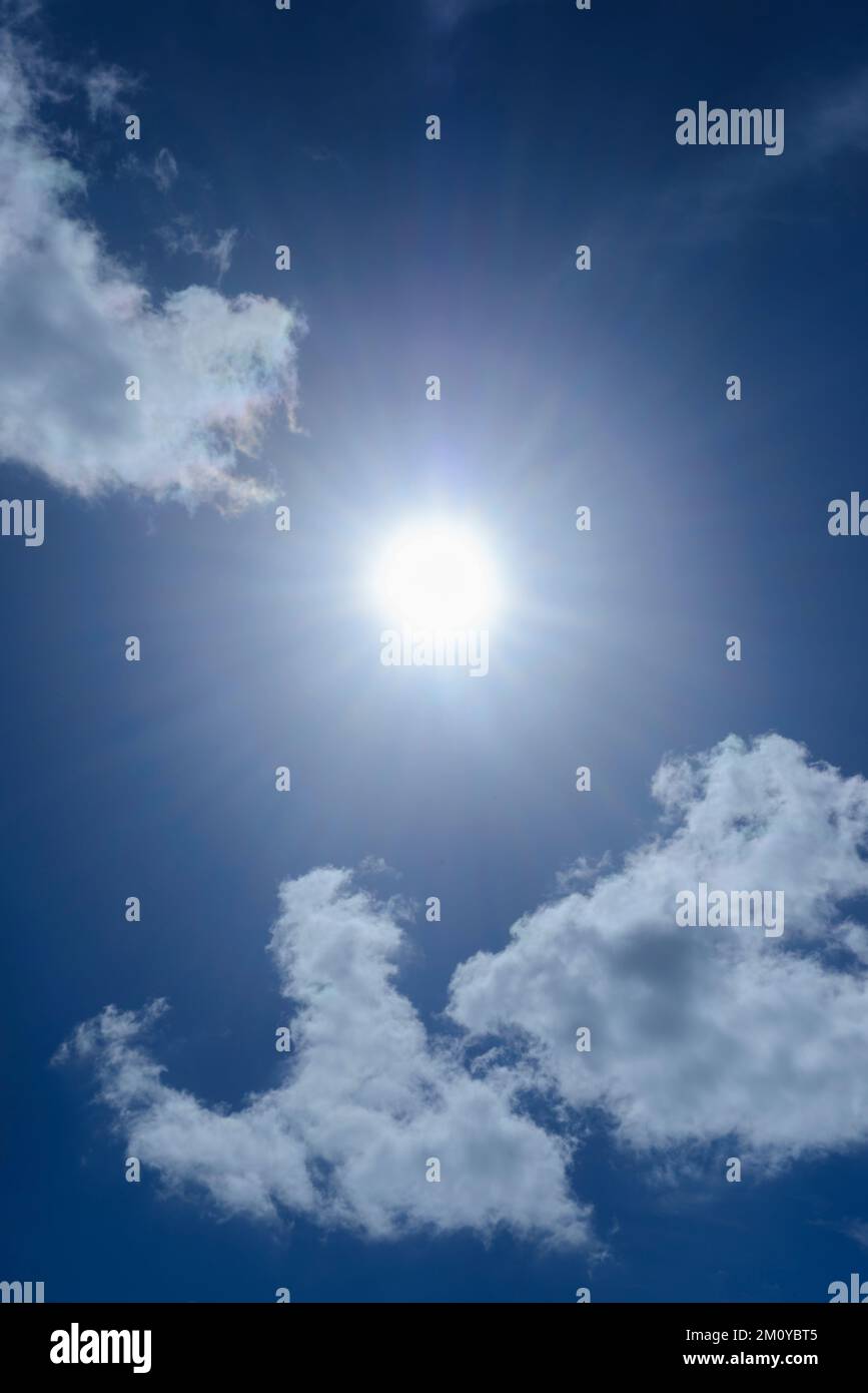 Clouds in the blue sky in winter. The bright midday sun illuminates the space Stock Photo