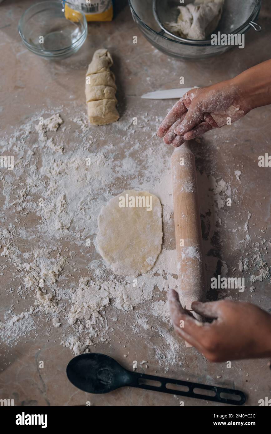 Close-up of young woman rolling dough with rolling pin Stock Photo