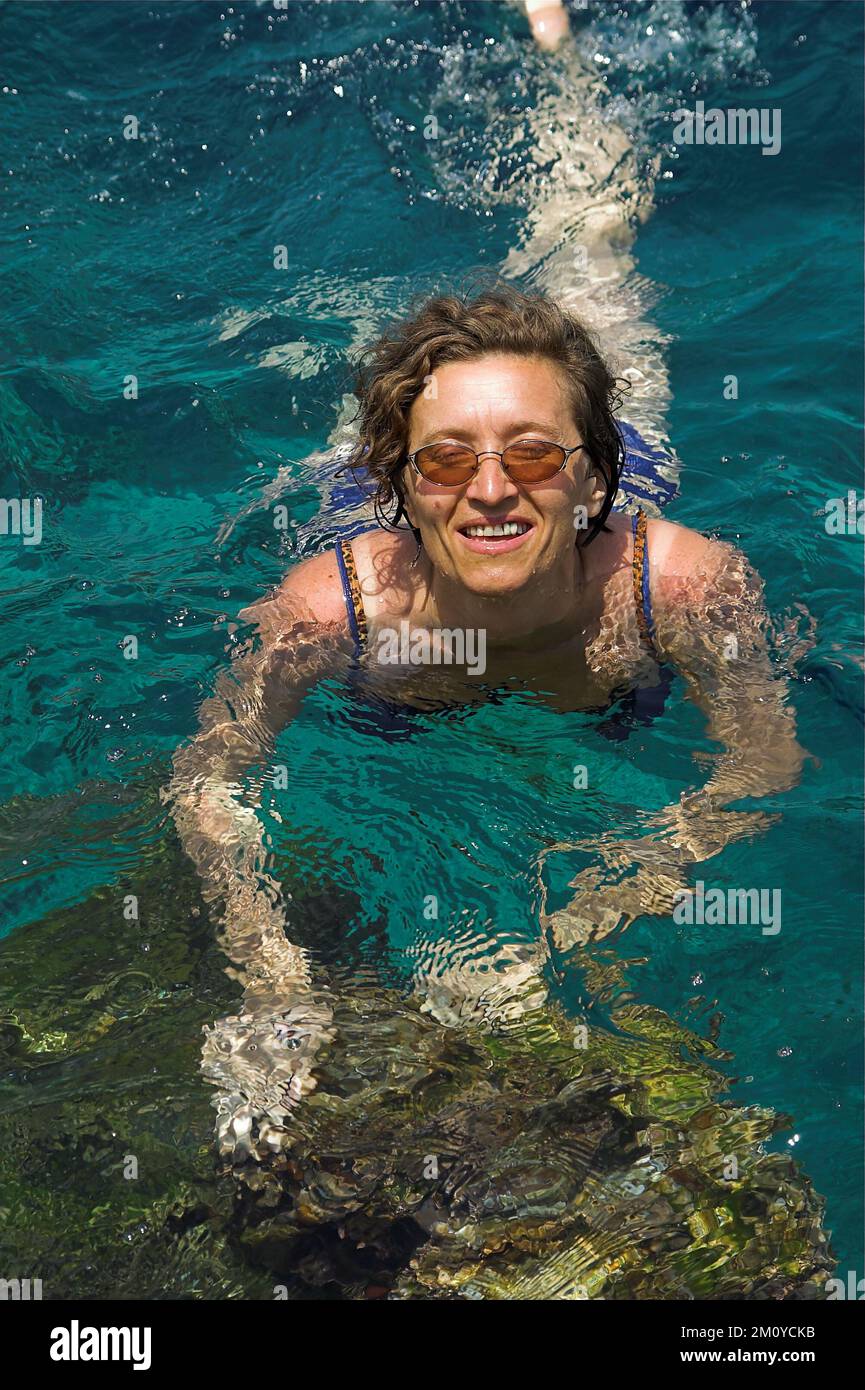 Hydra, Idra, Ύδρα, Grecja, Greece, Griechenland; A woman with glasses bathes in the sea; Eine Frau mit Brille badet im Meer; Kobieta kąpie się w morzu Stock Photo