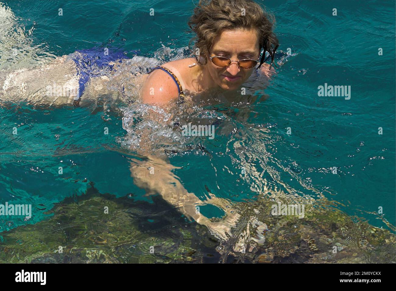 Hydra, Idra, Ύδρα, Grecja, Greece, Griechenland; A woman with glasses bathes in the sea; Eine Frau mit Brille badet im Meer; Kobieta kąpie się w morzu Stock Photo