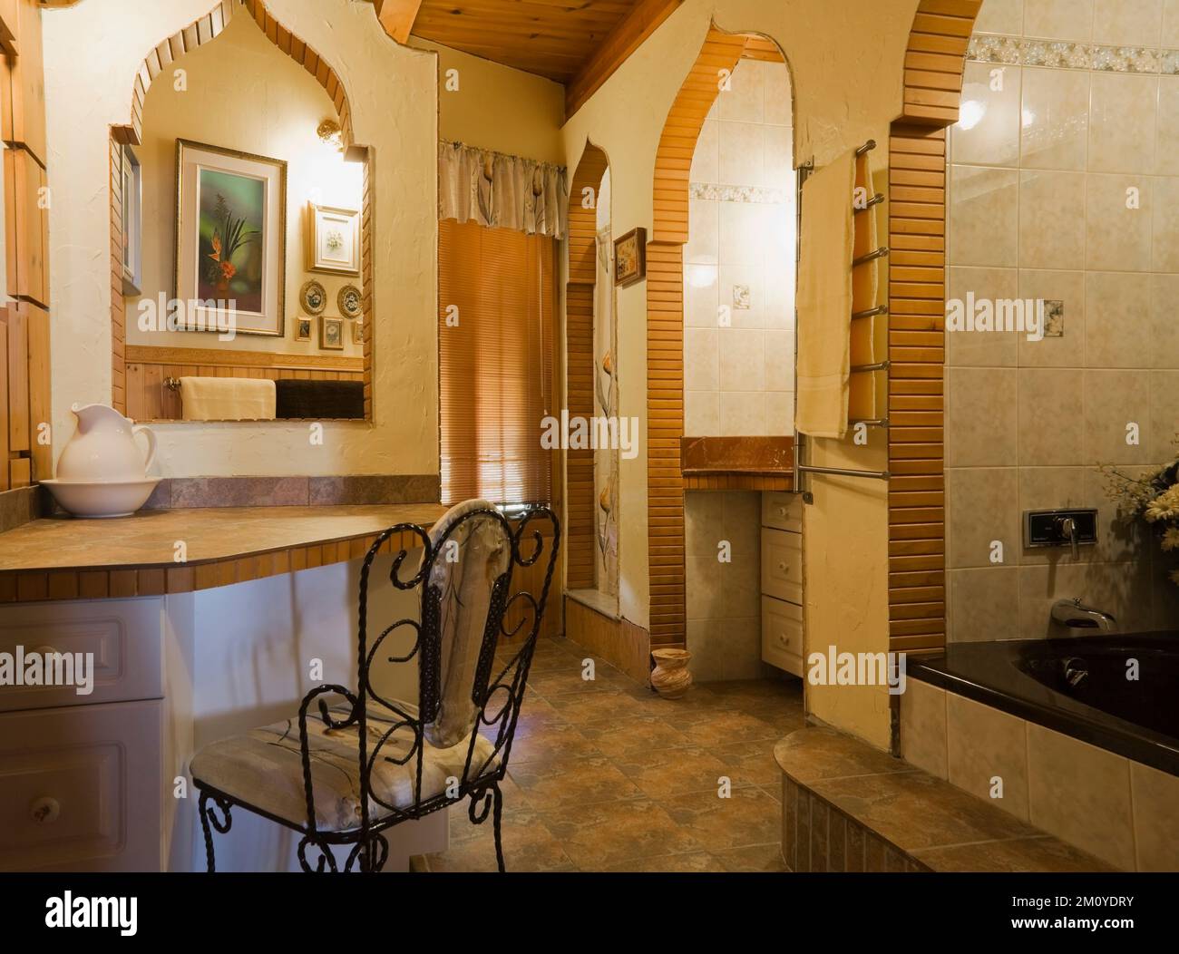 Dressing table counter and chair in spacious bathroom and powder room inside timber frame home. Stock Photo