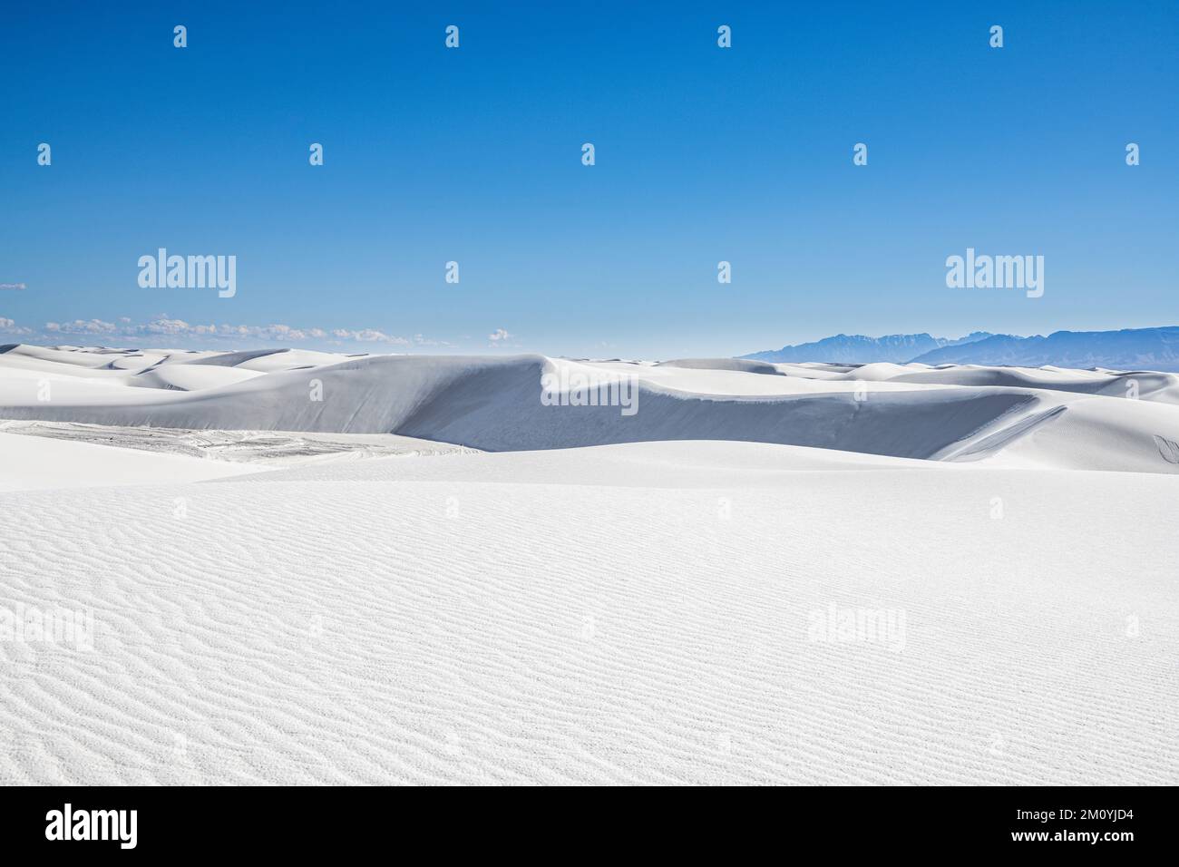 Vast, barren landscape of white sand dunes and distant mountains in White Sands National Park, New Mexico Stock Photo