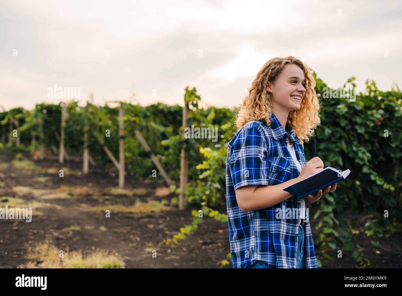 Woman specialist agronomist holding a notepad controlling the quality of the vineyards. Copy space. Harvest concept. Green business concept. Business Stock Photo