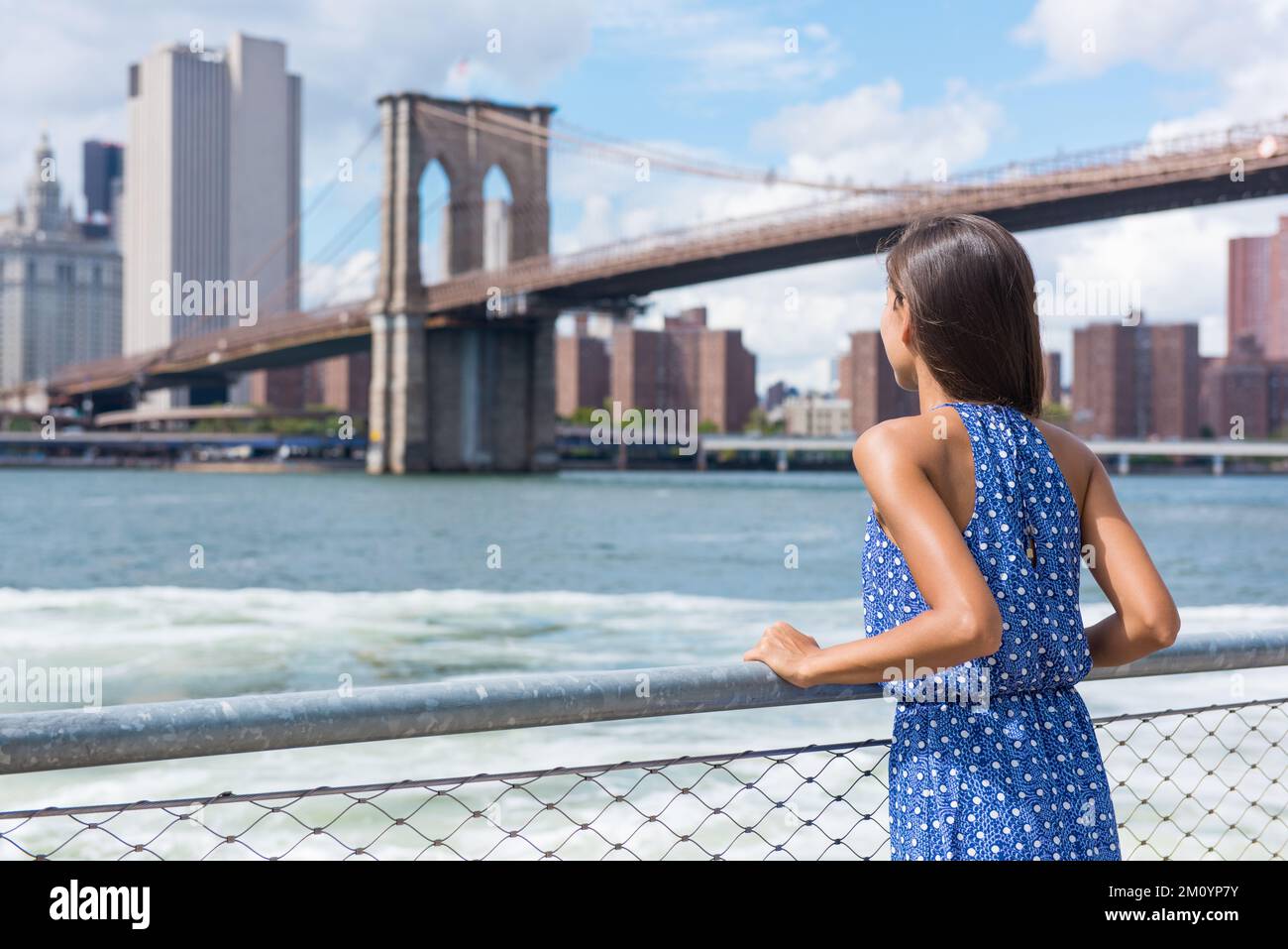 New York City woman looking at view of downtown Manhattan skyline from Brooklyn park living urban lifestyle walking during summer travel in USA Stock Photo