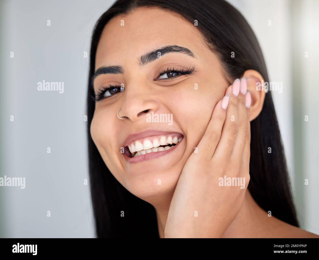 The softest skin ever. a young woman doing her skincare routine in a bathroom at home. Stock Photo