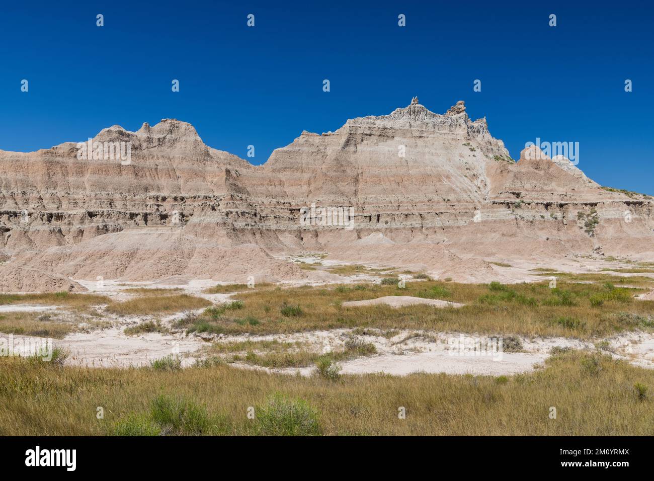 Rugged, colorful peaks above grassy meadows in Badlands National Park, South Dakota Stock Photo