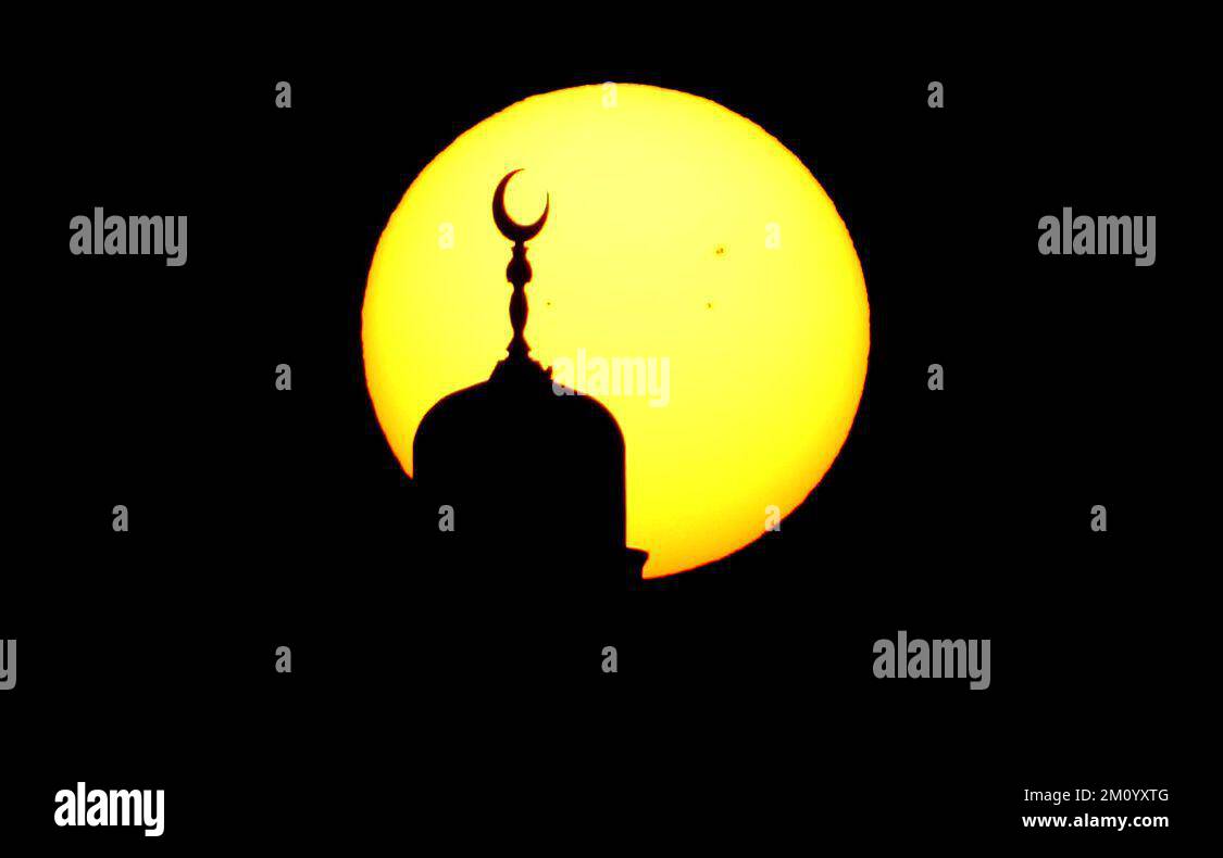The sun rises behind the Mosque at Souq Waqif in Doha, Qatar. Picture ...