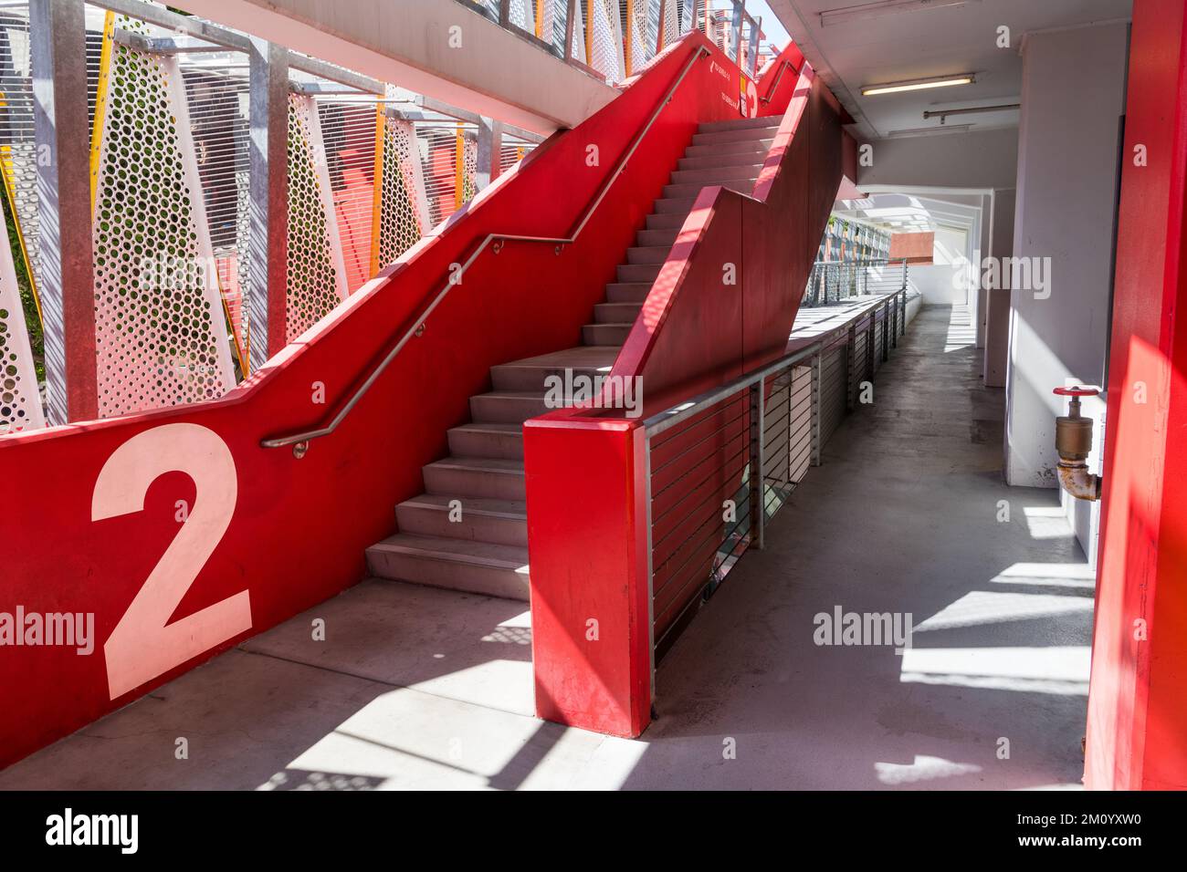 Modern structure of a parking garage with a concrete stairway with red
