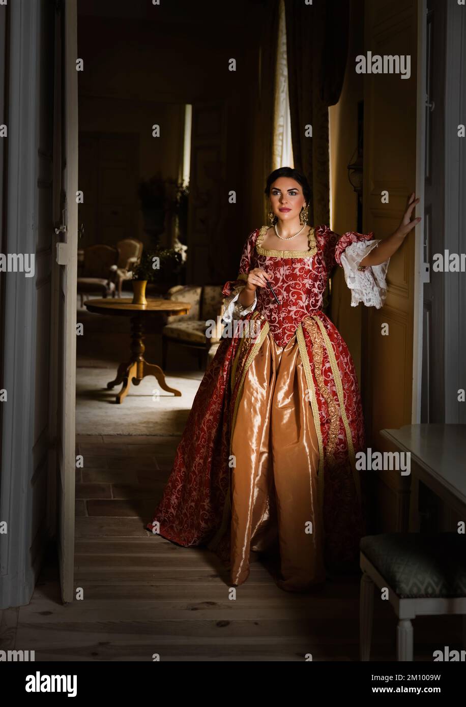 Beautiful woman in late renaissance costume posing between the open ...