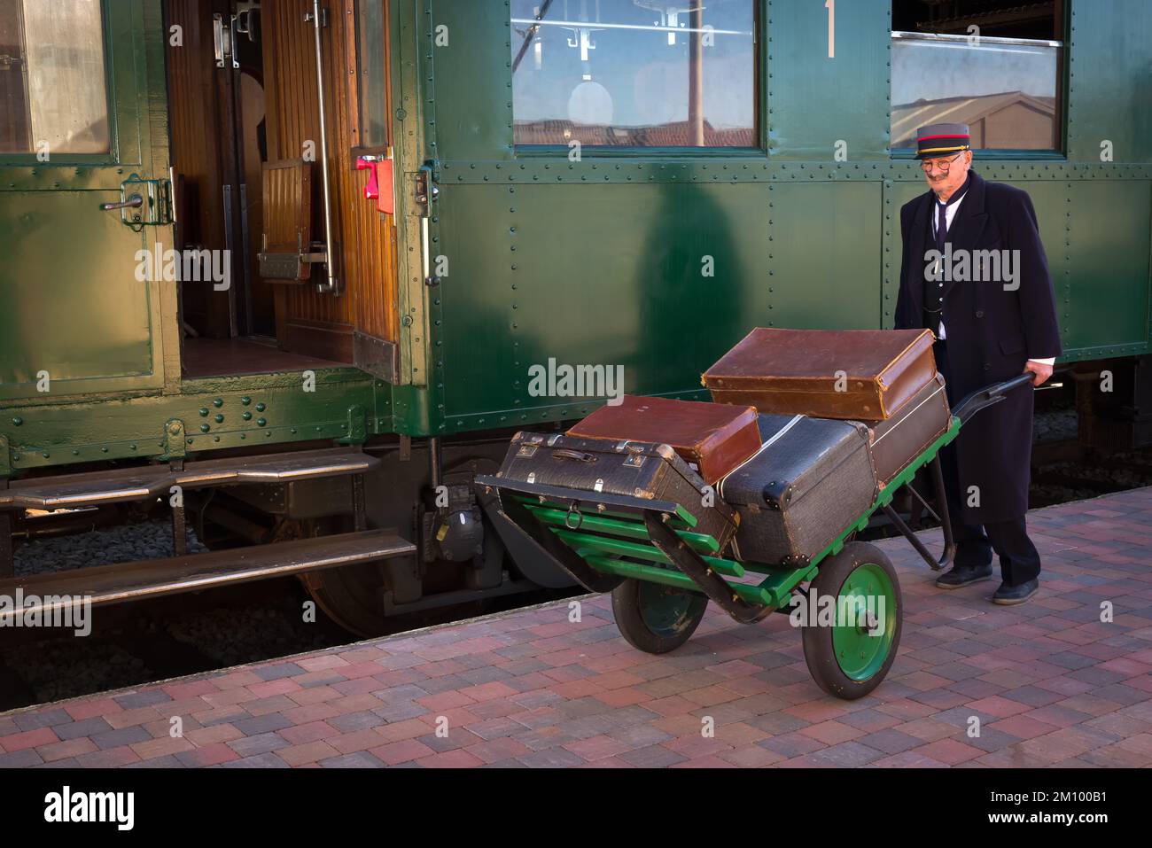 Vintage train baggage porter transporting luggage with an antique
