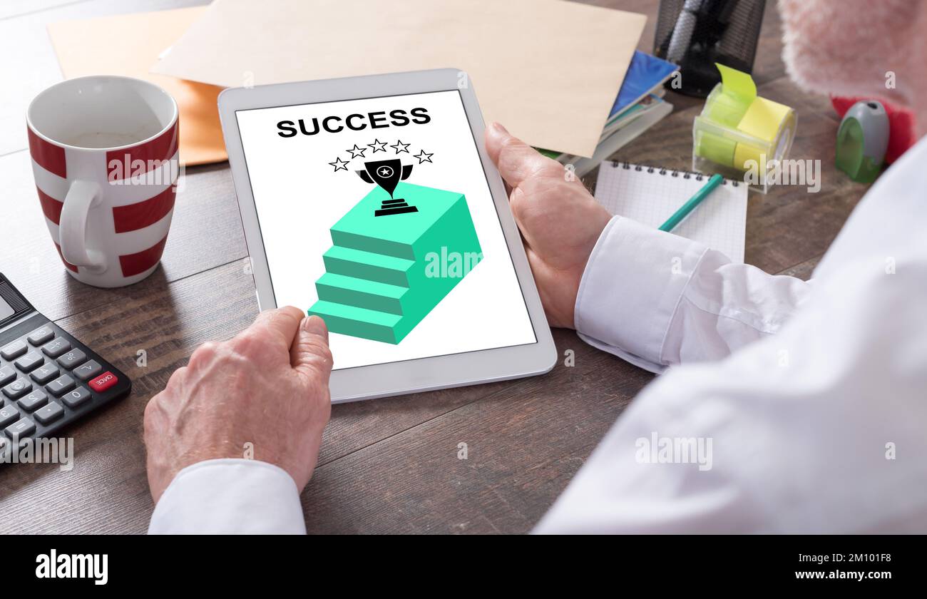 Success concept shown on a tablet held by a man Stock Photo