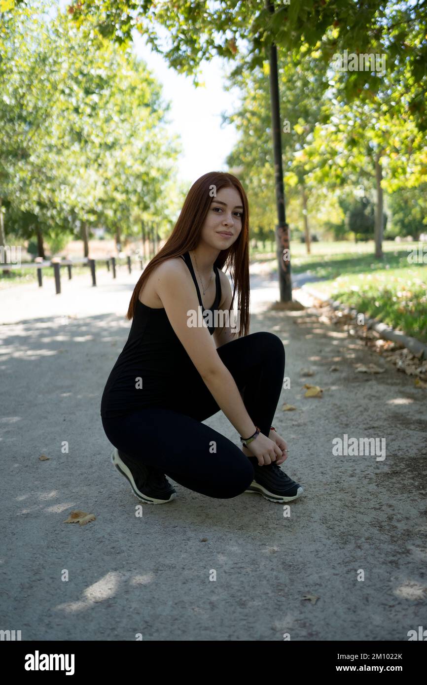Young woman sitting on skateboard Stock Photo
