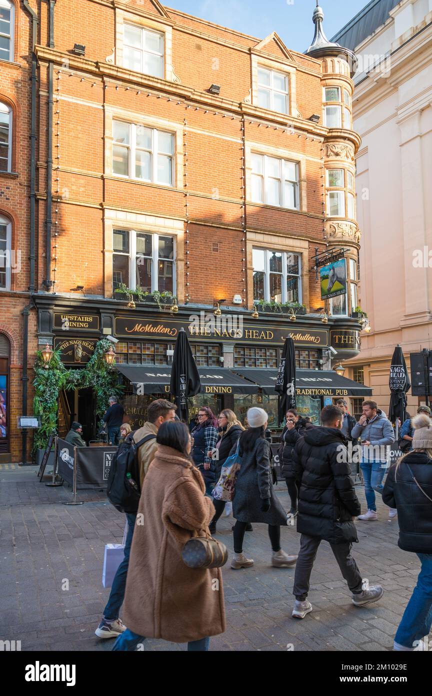 Covent Garden. People shopping pass by the Nags Head pub on James Street. London, England, UK Stock Photo