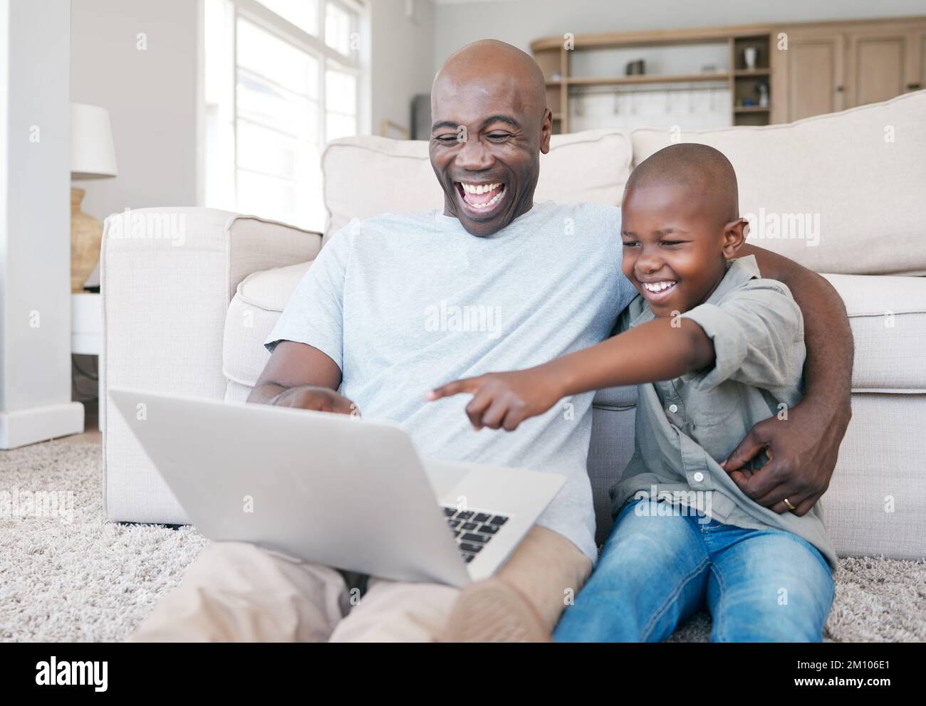 My family is my life. a father and son using a laptop on the sofa at home. Stock Photo
