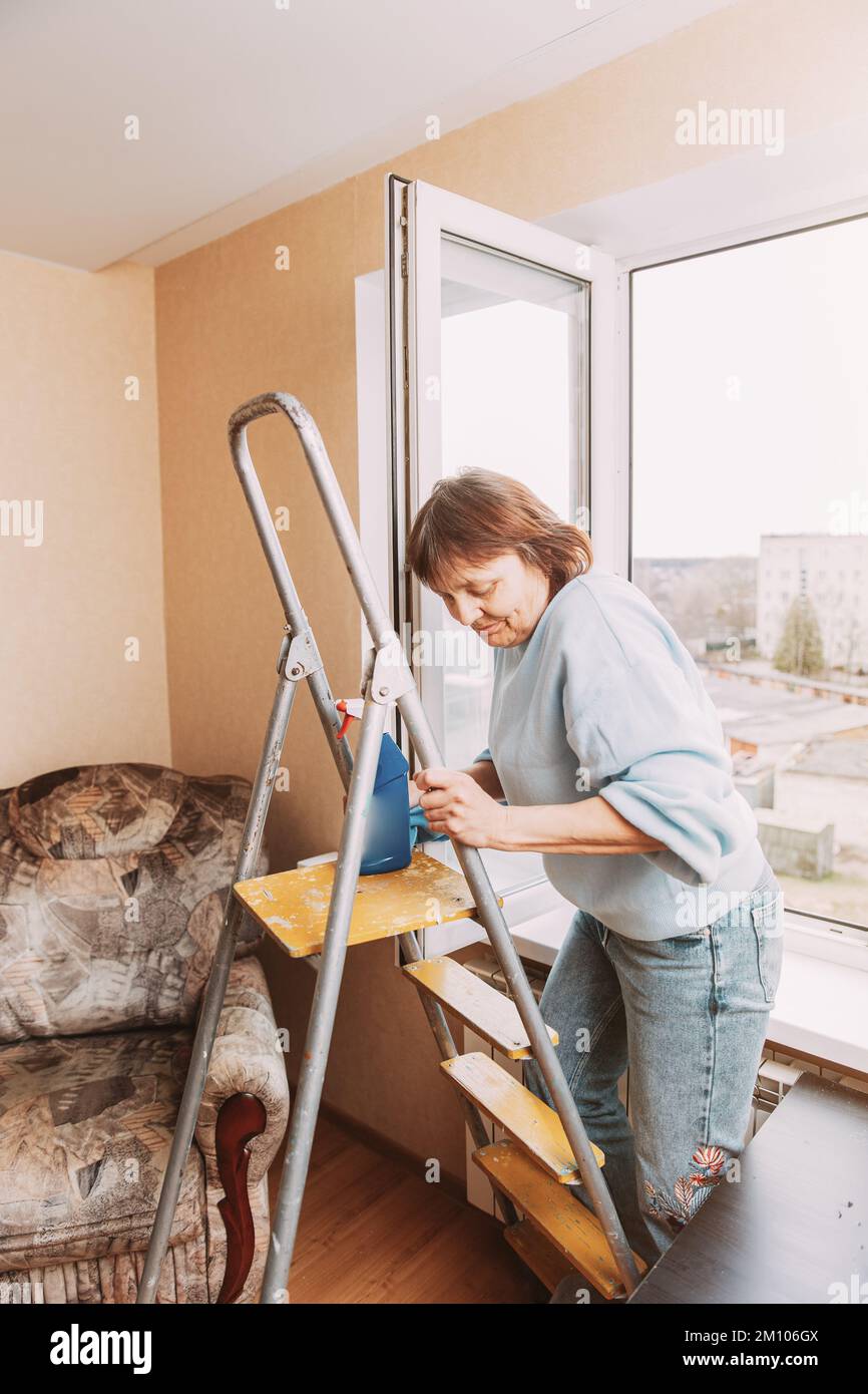 Happy Shy Mature Woman Cleaning House. Concept Of Household And People In Retirement. Elderly