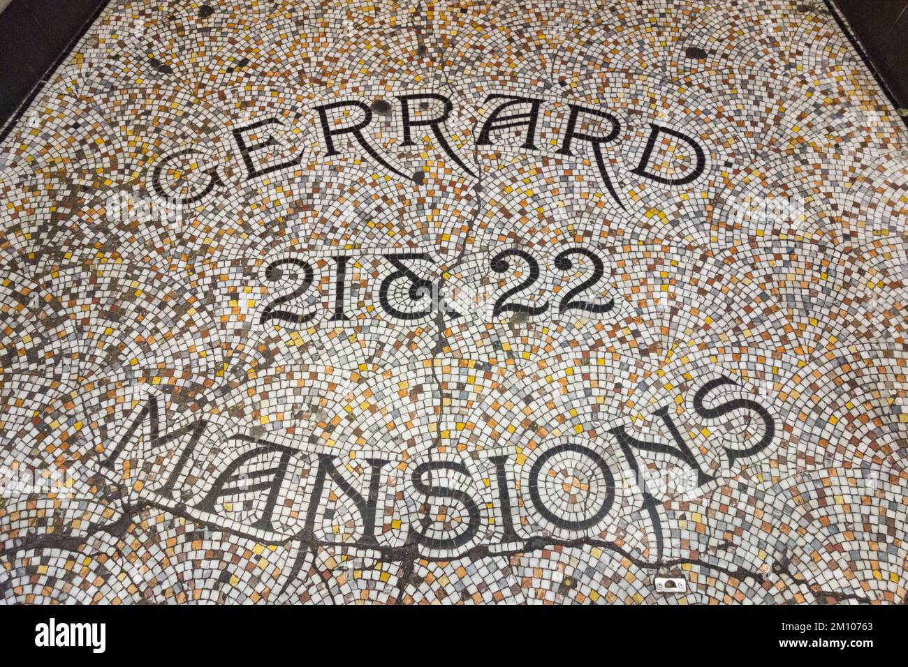 Cracked mosaic tiled doorstep at Gerrard Mansions, Gerrard Street, Soho, London, W1, England, UK Stock Photo